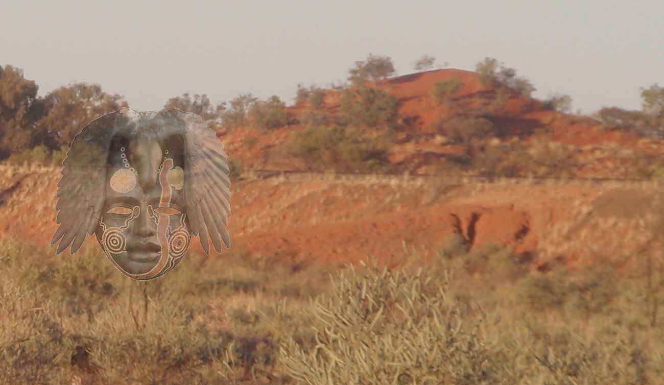 The Australian Dreaming Project image: red desert country with a faint carved face overlaid