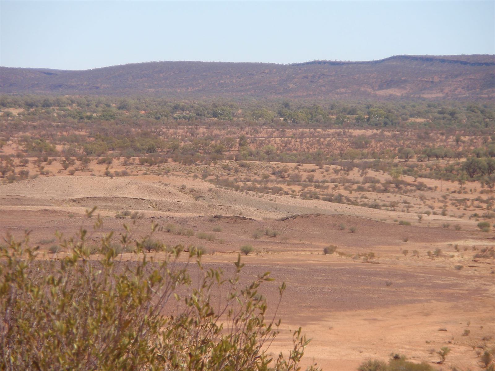 Wide view across red desert plains to distant ranges